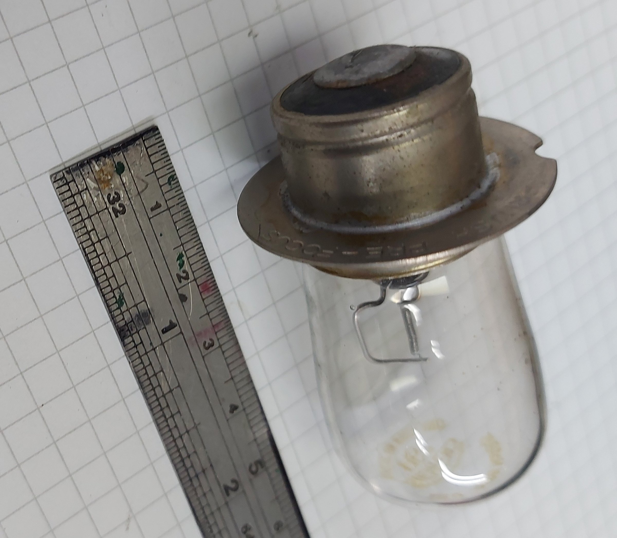 An original thermostat photographed beside a steel rule