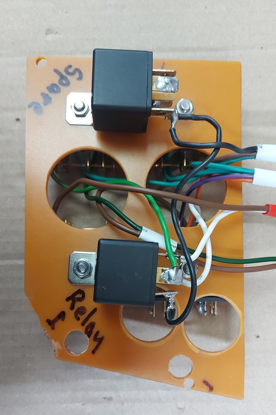 The reverse of a fuse board showing two relays and soldered connections